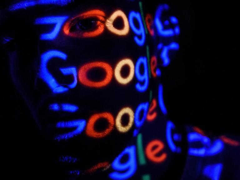 Foto-Illustration des "Google" Logos, dass auf einen Menschen projeziert wird.