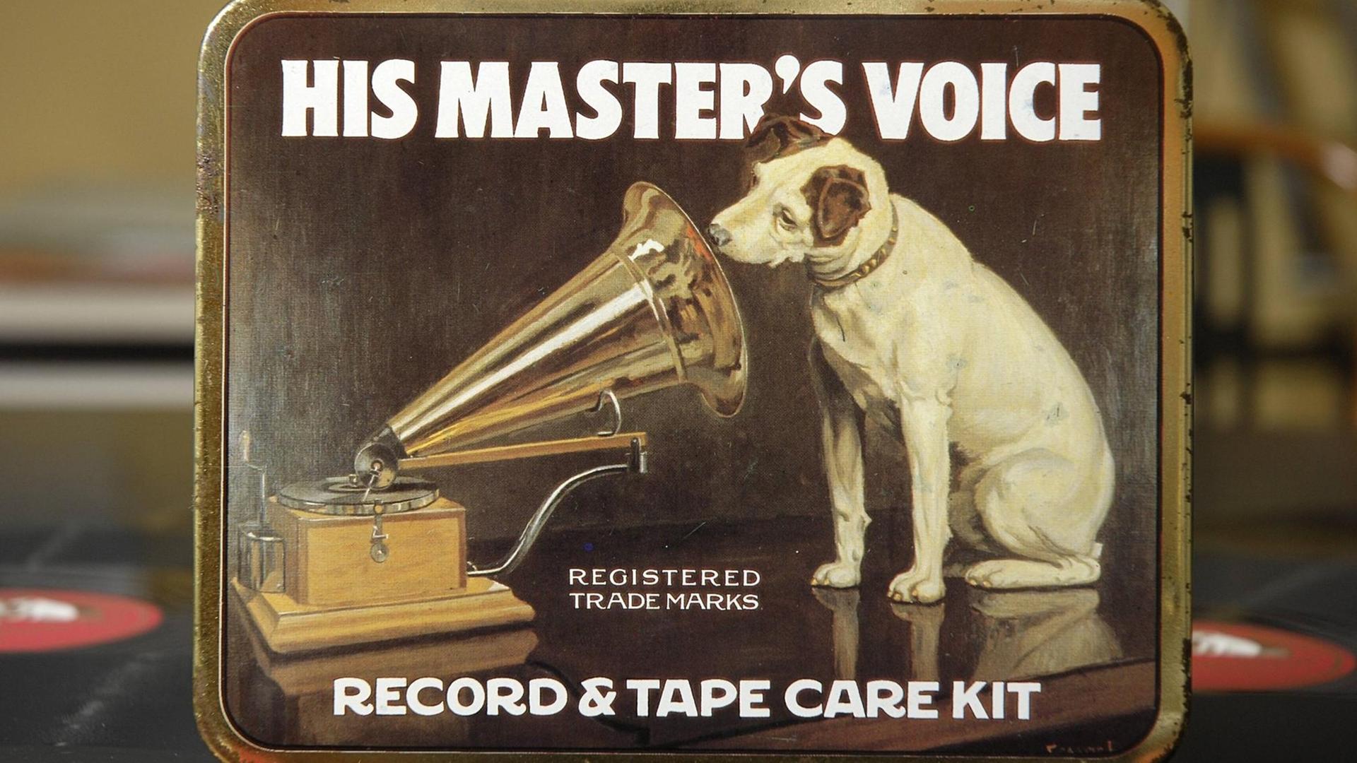 Eine kleine Metalldose, mit Pflegematerialen für Aufnahmegeräte. Auf dem Deckel ist der kleine Terrier Nipper abgebildet, der vor einem alten Grammophon sitzt und in den Schalltrichter lauscht. Eine kleine Metalldose, mit Pflegematerialen für Aufnahmegeräte. Auf dem Deckel ist der kleine Terrier Nipper abgebildet, der vor einem alten Grammophon sitzt und in den Schalltrichter lauscht.