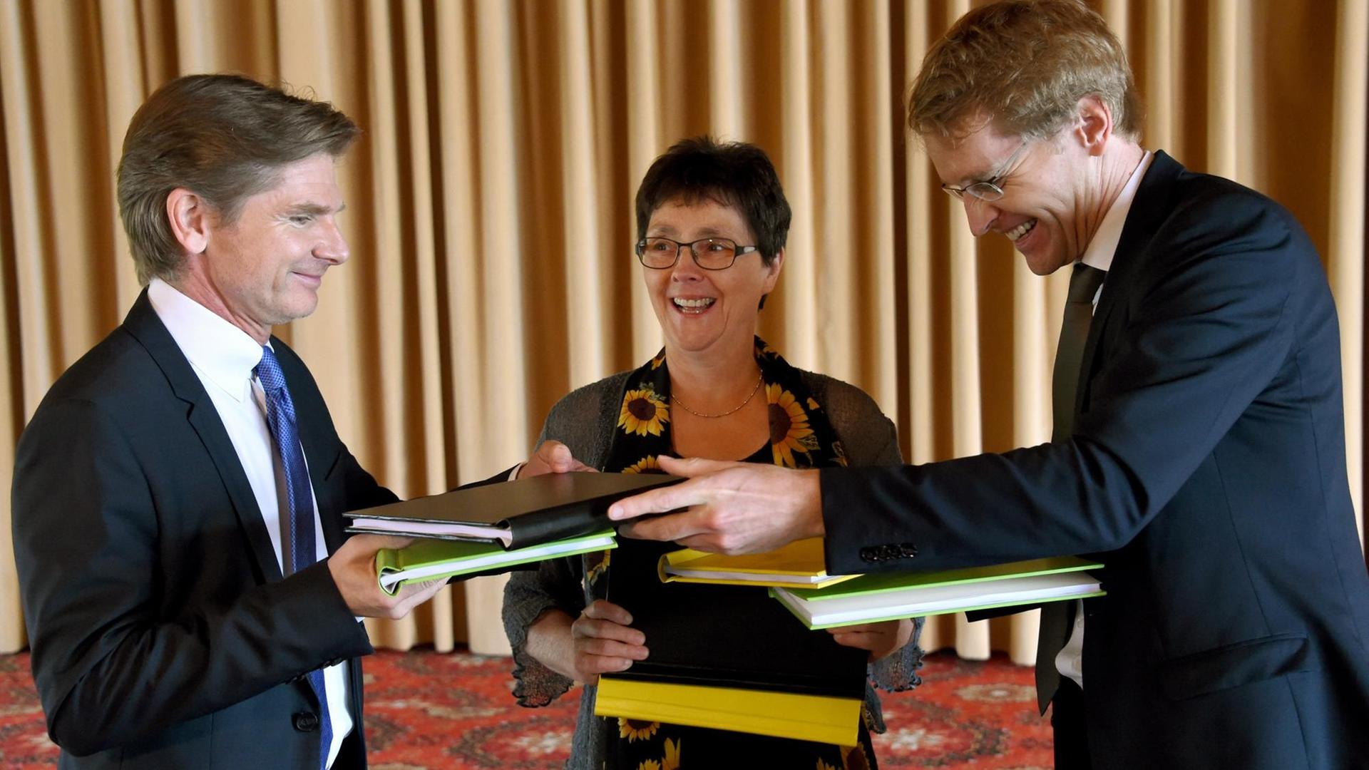 Die Verhandlungsführer der schleswig-holsteinischen Koalitionsverhandlungen, (l-r) Heiner Garg (FDP), Monika Heinold (Bündnis 90/Die Grünen) und Daniel Günther (CDU), hantieren am 16.06.2017 in Kiel (Schleswig-Holstein) mit den Koalitionsverträgen. Die Verhandlungsführer der schleswig-holsteinischen Koalitionsverhandlungen, (l-r) Heiner Garg (FDP), Monika Heinold (Bündnis 90/Die Grünen) und Daniel Günther (CDU), hantieren am 16.06.2017 in Kiel (Schleswig-Holstein) mit den Koalitionsverträgen.
