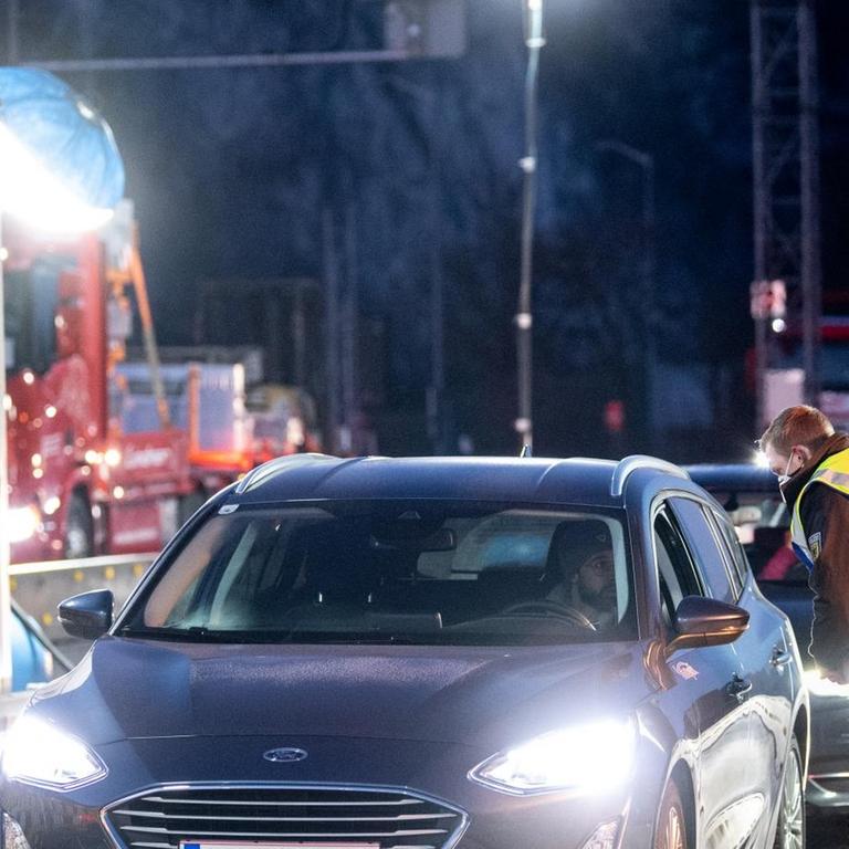 Zwei Bundespolizisten kontrollieren die Dokumente von Reisenden an der Autobahn A93 bei Kiefersfelden in Richtung Deutschland.