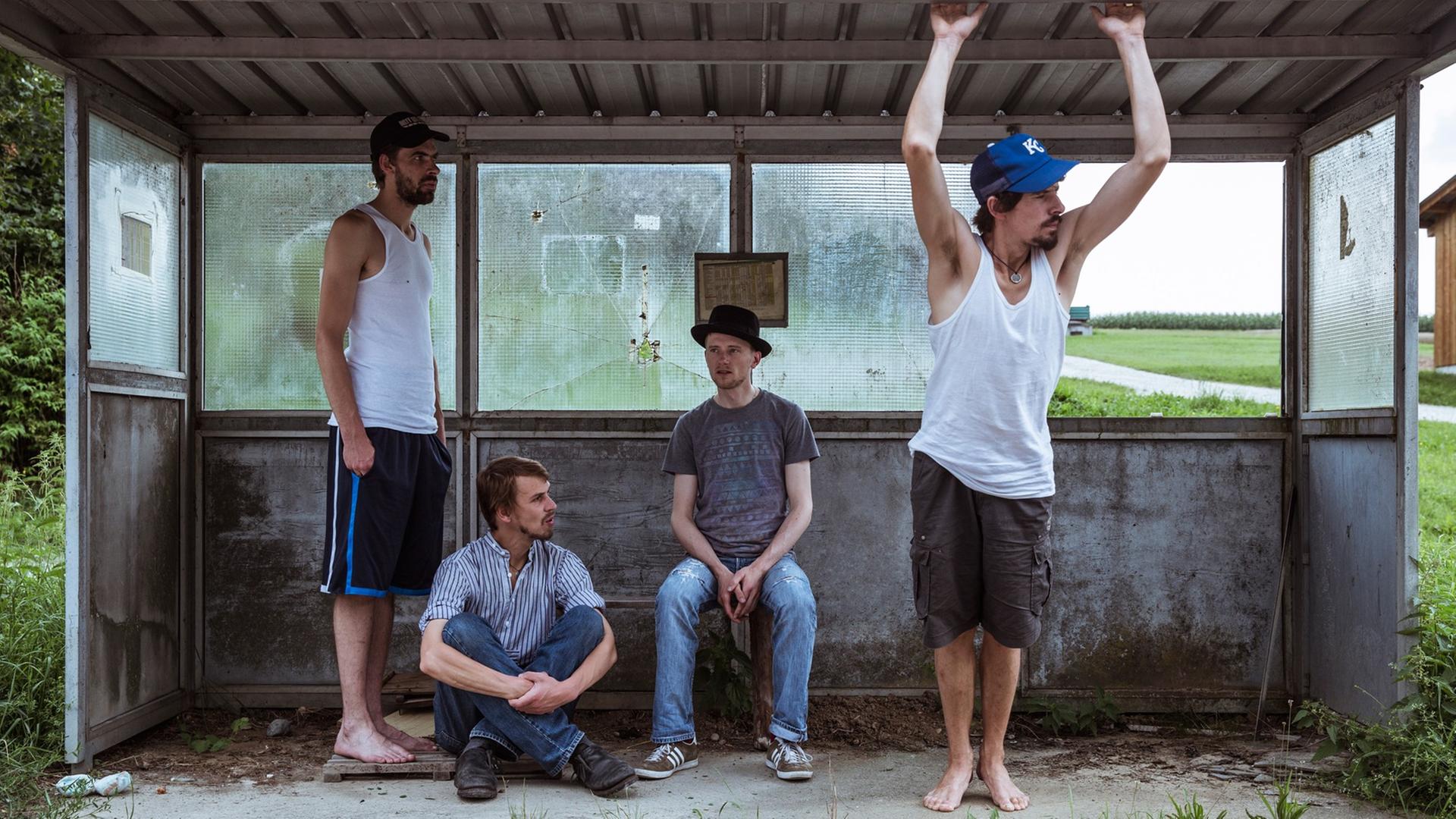 Die Mitglieder der Band "Kofelgschroa" stehen und hocken in einer alten Bushaltestelle Die Mitglieder der Band "Kofelgschroa" stehen und hocken in einer alten Bushaltestelle
