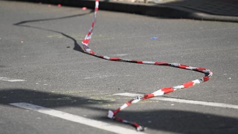 Ein Absperrband flattert in Volkmarsen auf der Straße über den Spuren des Tatorts.
