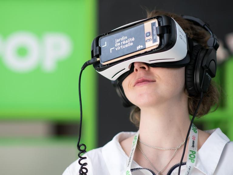 Eine Besucherin aus München schaut sich bei der Internetkonferenz "re:publica 2018" Virtual-Reality-Kurzfilme an.
