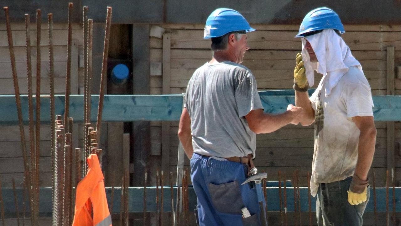 Bauarbeiter auf einer Baustelle arbeiten trotz sengender Hitze