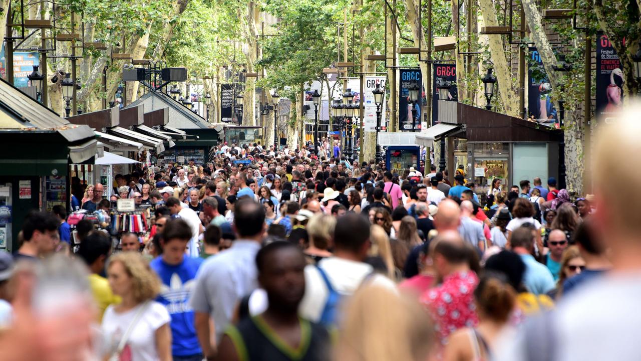 Touristen gehen am 21.07.2017 durch die Einkaufsstraße La Rambla in der Innenstadt von Barcelona (Spanien). 
