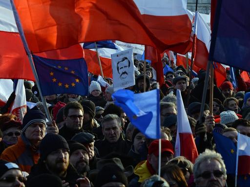 Demonstranten protestieren in Warschau gegen die Regierung. Viele Menschen schwenken die Fahnen Polens und der EU.