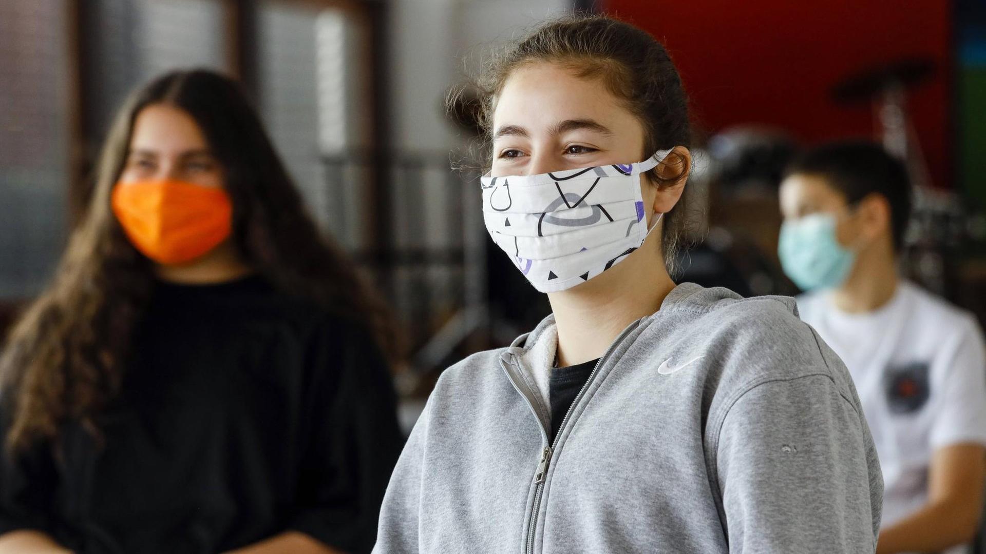 Realschule Benzenberg anlaesslich der Wiederaufnahme des Schulbetriebs unter Auflagen des Corona-Infektionsschutzes in Zeiten der Corona Pandemie, Schuelerinnen tragen Masken beim Unterricht im Musikraum.