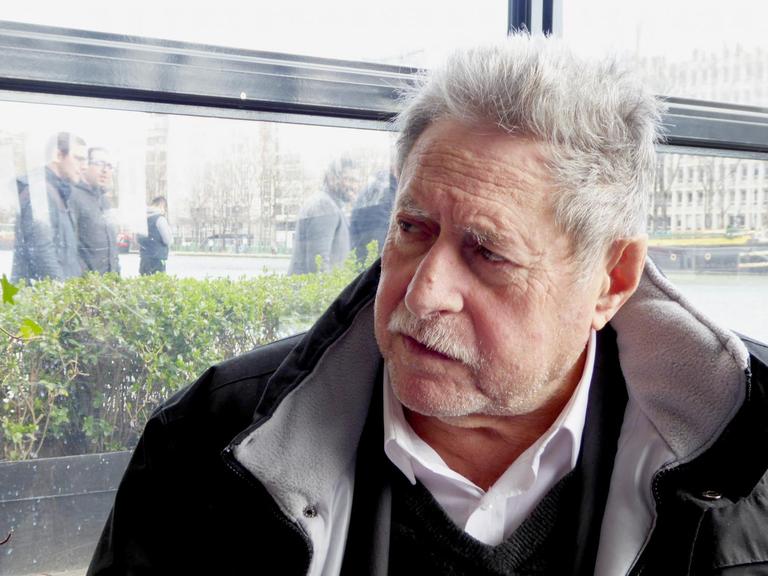 Porträtaufnahme Sammy Ghozlan: ein älterer Mann mit weiß-grauem Haar und Schnurrbart und dunkler Jacke.