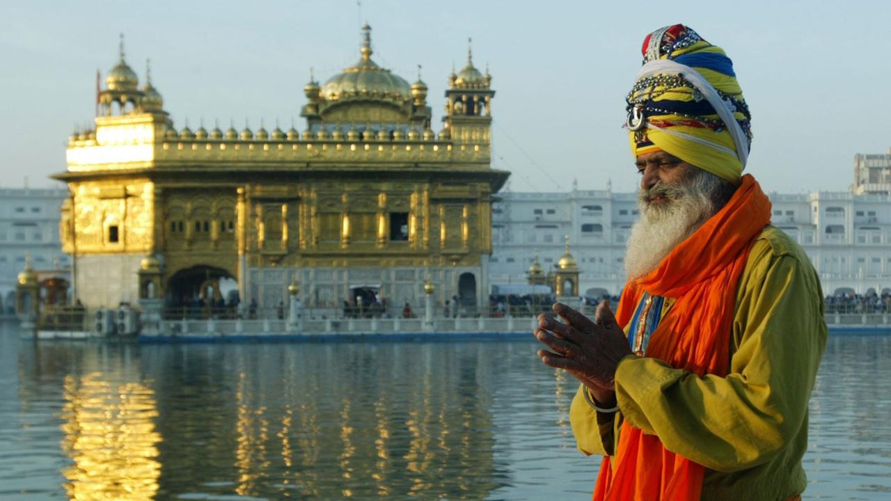 Ein "Nihang", ein bewaffneter Sikh-Krieger, betet vor dem Heiligtum der Sikhs, dem goldenen Tempel Amritsar im indischen Bundesstaat Punjab Ein "Nihang", ein bewaffneter Sikh-Krieger, betet vor dem Heiligtum der Sikhs, dem goldenen Tempel Amritsar im indischen Bundesstaat Punjab