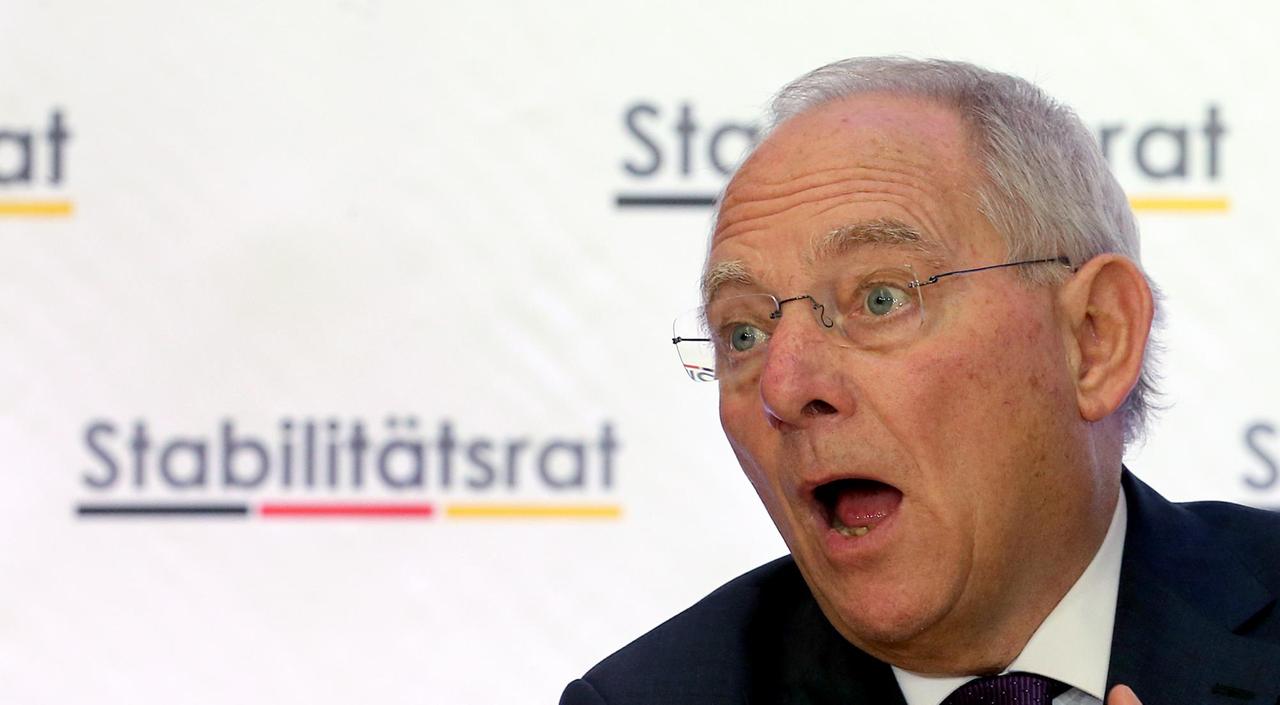 Wolfgang Schäuble, Porträt, sprechend und mit einer Hand gestikulierend, vor einer weißen Wand mit der Aufschrift "Stabilitätsrat".