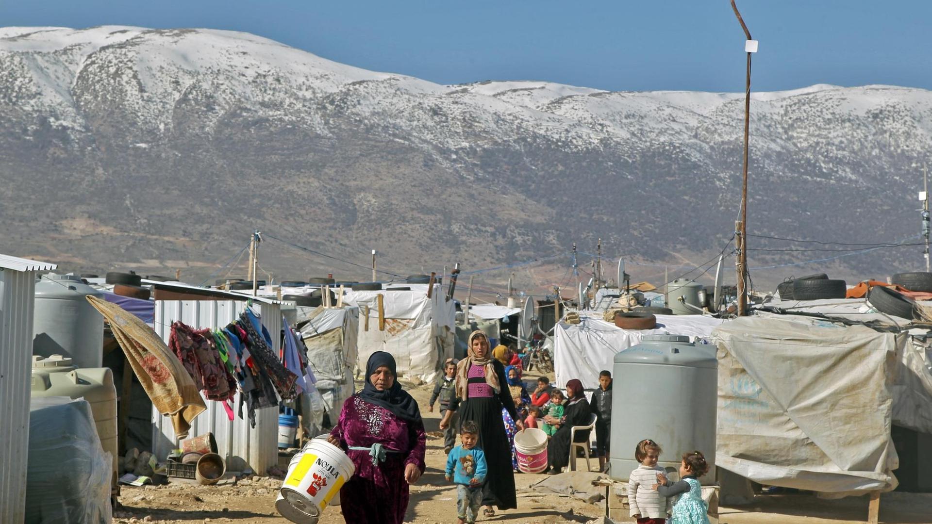 ibanon, Mardsch: Syrische Flüchtlinge gehen durch ein Flüchtlingslager in der Bekaa-Ebene. ibanon, Mardsch: Syrische Flüchtlinge gehen durch ein Flüchtlingslager in der Bekaa-Ebene.