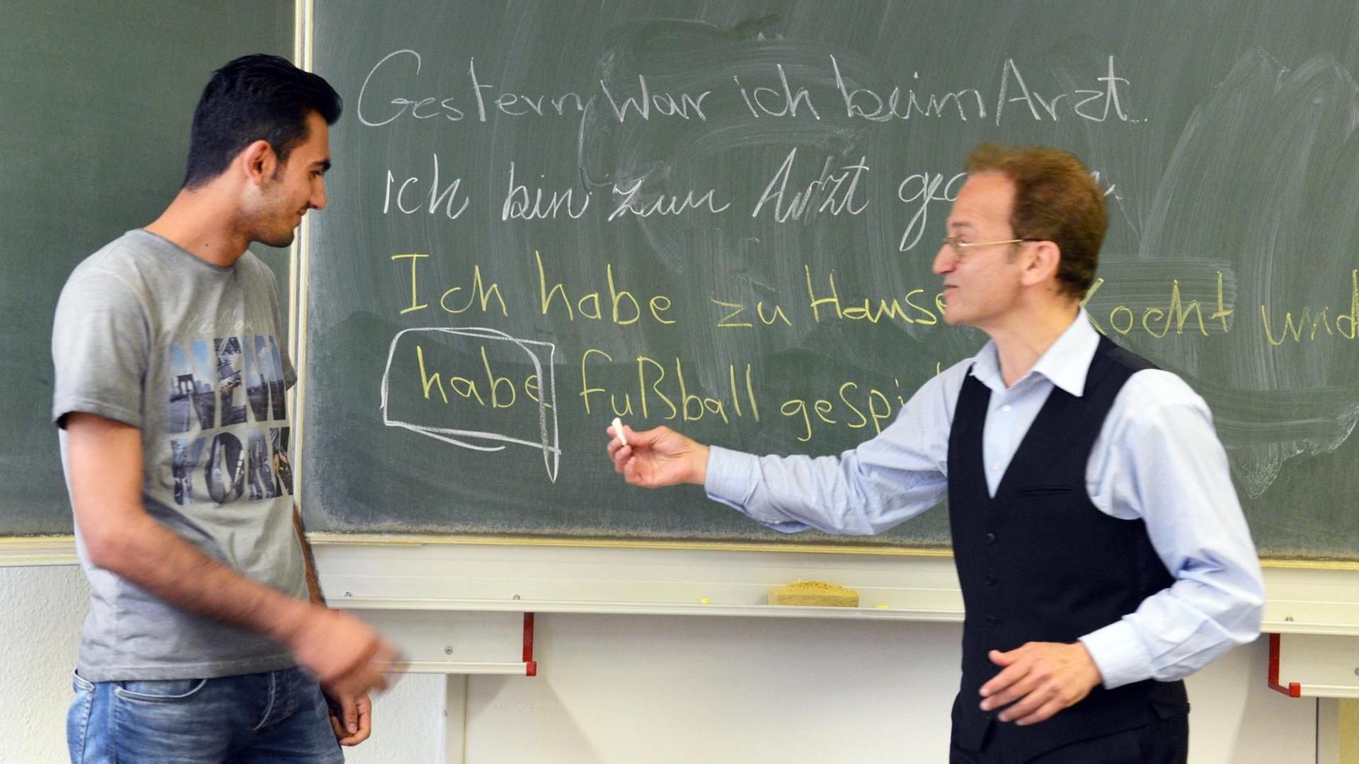 In der Volkshochschule in Leipzig steht Samer Alale aus Syrien (l) mit seinem Lehrer Mounir Taoubi beim Deutsch-Unterricht im Integrationskurs an der Tafel. In der Volkshochschule in Leipzig steht Samer Alale aus Syrien (l) mit seinem Lehrer Mounir Taoubi beim Deutsch-Unterricht im Integrationskurs an der Tafel.