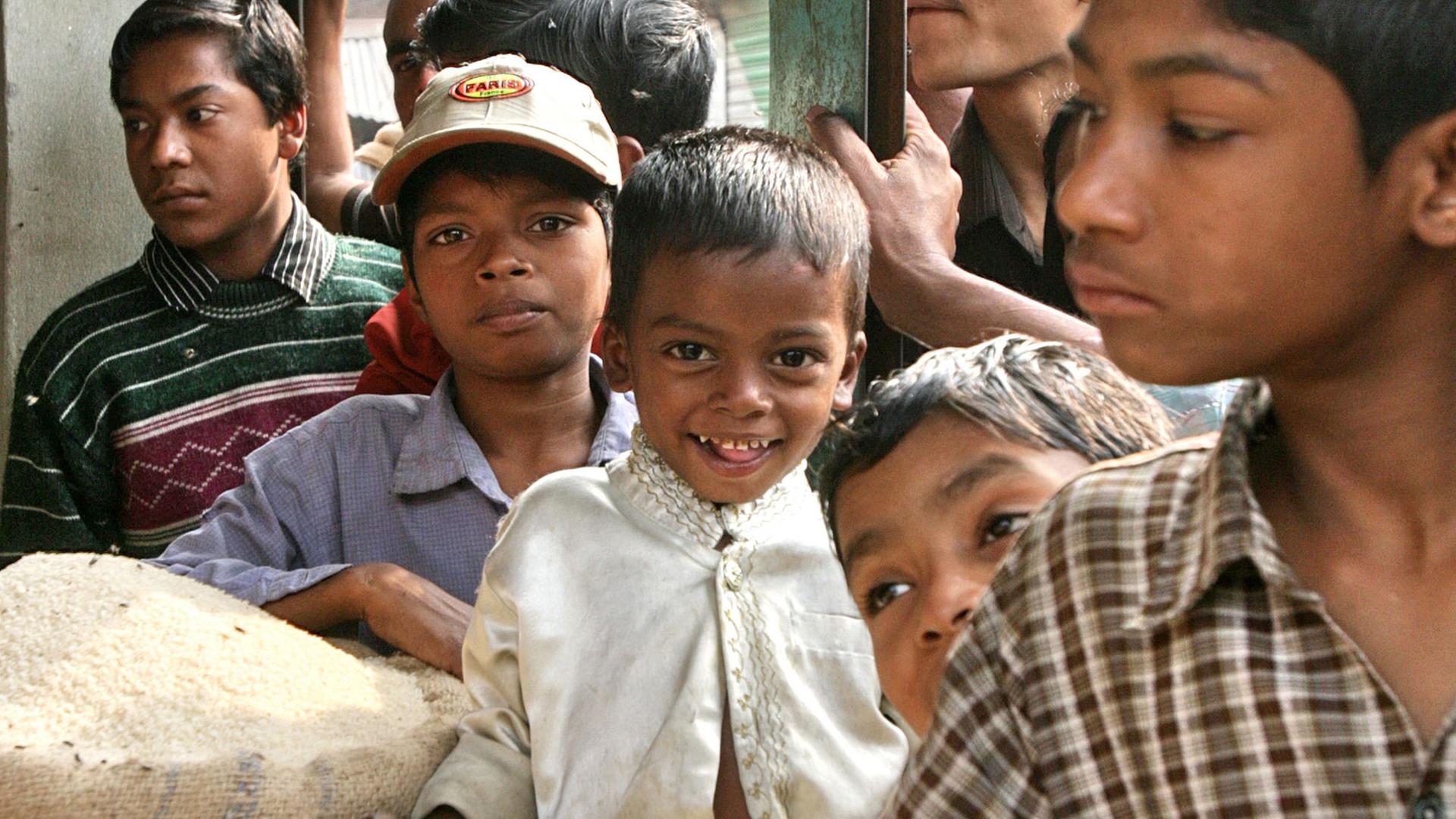 Kinder stehen in Bangladesch vor einem Marktstand, wo es günstigen Reis gibt. Kinder stehen in Bangladesch vor einem Marktstand, wo es günstigen Reis gibt.
