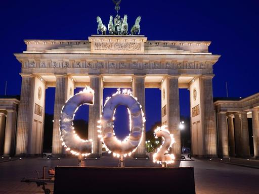Bei einer Greenpeace-Aktion steht ein CO-2 Schriftzug vor dem Brandenburger Tor, aus dem Flammen schlagen. Mit der Aktion fordern Aktivisten der Umweltschutz-Organisation Greenpeace die Bundesregierung auf, den CO-2 Ausstoß in Deutschland weiter zu reduzieren und auf die Einhaltung der Ziele des Weltklimagipfels von Paris zu achten.