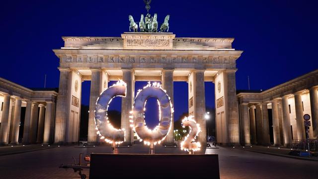 Bei einer Greenpeace-Aktion steht ein CO-2 Schriftzug vor dem Brandenburger Tor, aus dem Flammen schlagen. Mit der Aktion fordern Aktivisten der Umweltschutz-Organisation Greenpeace die Bundesregierung auf, den CO-2 Ausstoß in Deutschland weiter zu reduzieren und auf die Einhaltung der Ziele des Weltklimagipfels von Paris zu achten.