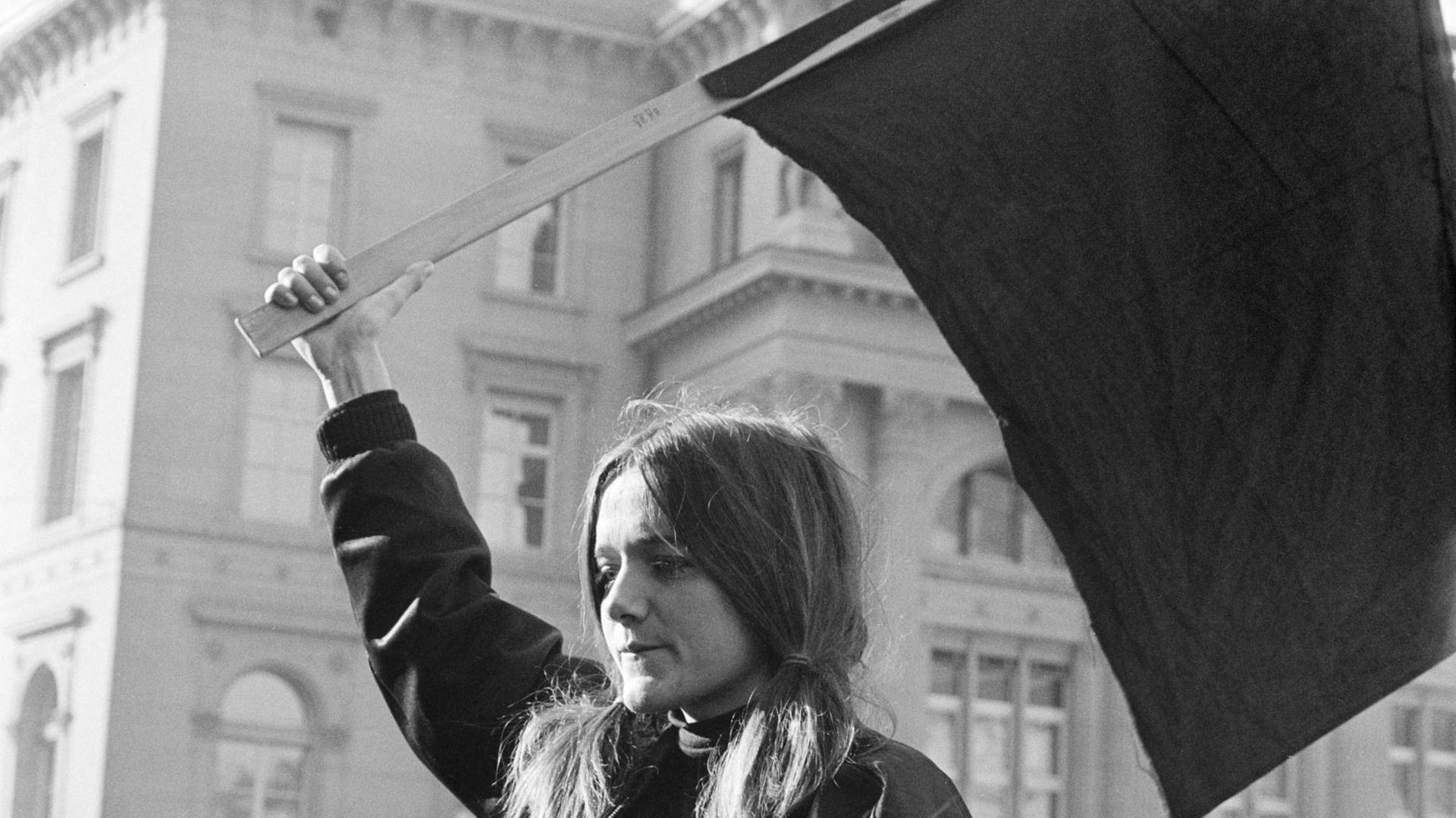 Das Schwarz-weiß-Foto von 1969 zeigt eine junge blonde Frau mit einer Fahne in der Hand. Das Schwarz-weiß-Foto von 1969 zeigt eine junge blonde Frau mit einer Fahne in der Hand.