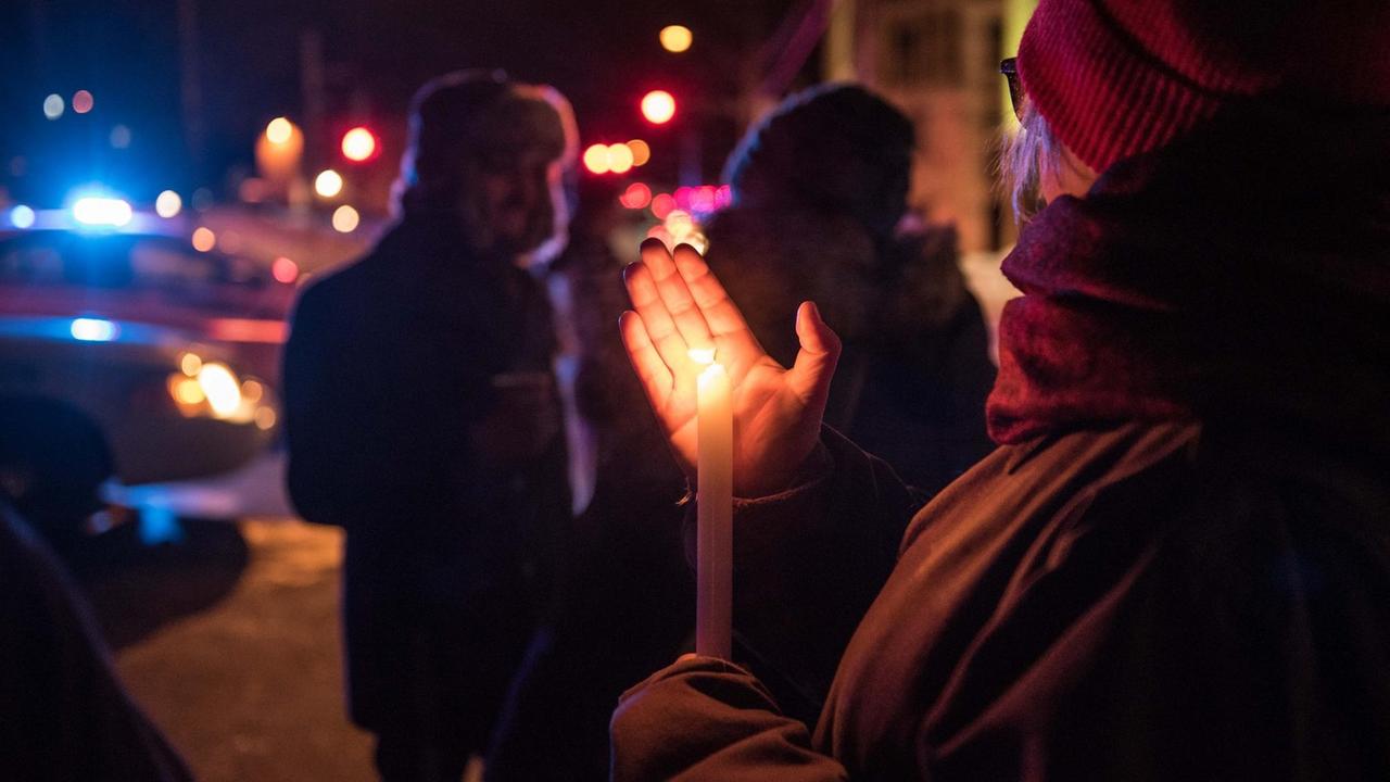 Eine Frau hält eine brennende Kerze nach dem Attentat auf eine Moschee im kanadischen Québec.