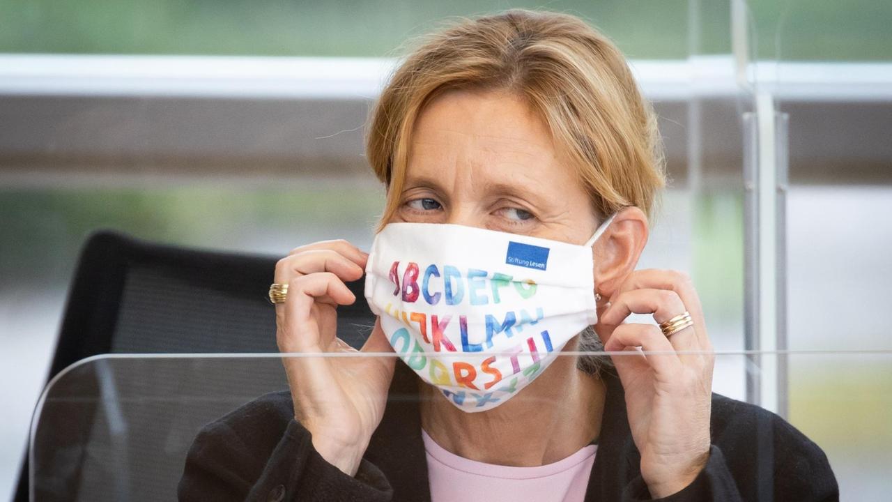 Karin Prien (CDU), Bildungsministerin von Schleswig-Holstein, trägt eine Maske mit den Buchstaben des Alphabets während einer Landtagssitzung.
