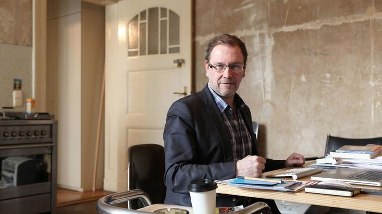 Rene Pollesch sitz in seinem Büro mit Berliner Altbaucharme.