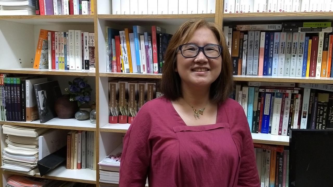 Geschichts-Professorin Hua Yih-Fen von rennomierteste Universität in Taiwan steht vor einer Bücherwand in ihrem Büro.