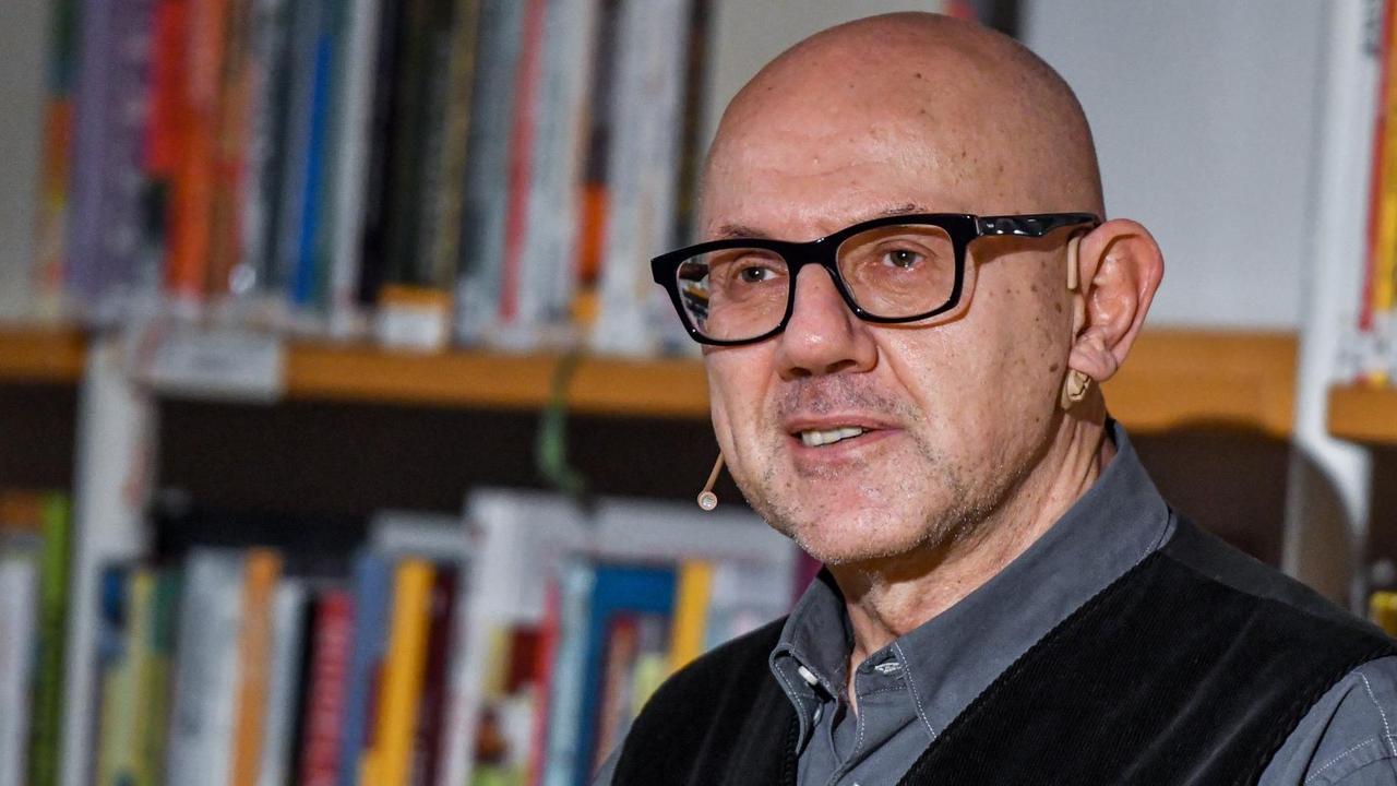 Andreas Pflüger steht vor einem Bücherregal in der Stadt- und Regionalbibliothek in Erfurt. Er hat eine Glatze, trägt eine Brille mit kräftigem, schwarzem Rand, hat ein graues Hemd und eine schwarze Weste an. Andreas Pflüger steht vor einem Bücherregal in der Stadt- und Regionalbibliothek in Erfurt. Er hat eine Glatze, trägt eine Brille mit kräftigem, schwarzem Rand, hat ein graues Hemd und eine schwarze Weste an.