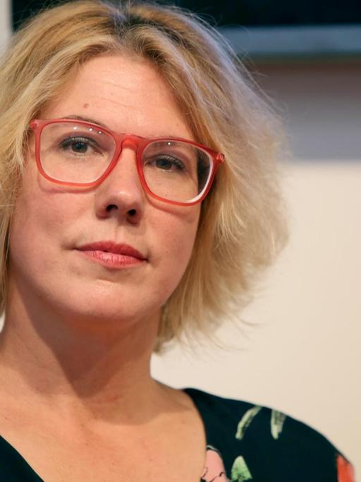 Porträtfoto der Autorin Nina George. Sie hat blondes Haar und trägt eine rote Brille. Foto: Susannah V. Vergau/dpa