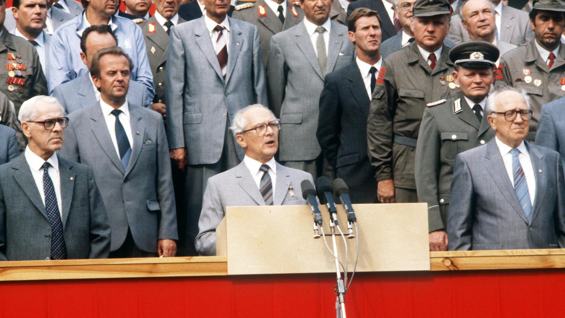 Der DDR-Partei- und Staatschef Erich Honecker bei seiner Rede anläßlich einer Parade in der Karl-Marx-Allee in Berlin (Ost) zum 25. Jahrestages des Baus des "antifaschistischen Schutzwalles", aufgenommen am 13.08.1986. Der DDR-Partei- und Staatschef Erich Honecker bei seiner Rede anläßlich einer Parade in der Karl-Marx-Allee in Berlin (Ost) zum 25. Jahrestages des Baus des "antifaschistischen Schutzwalles", aufgenommen am 13.08.1986.