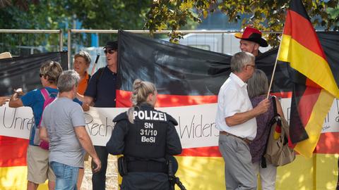 Eine Polizistin steht vor Teilnehmern einer Demonstration der islamfeindlichen Pegida-Bewegung in Dresden