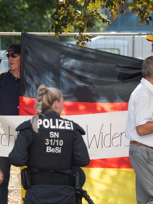Eine Polizistin steht vor Teilnehmern einer Demonstration der islamfeindlichen Pegida-Bewegung in Dresden
