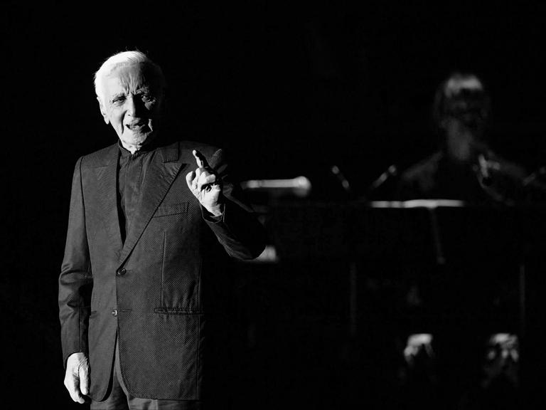 Ein schwarz-weiß Bild des französischen Sängers Charles Aznavour auf der Bühne während eines Konzerts in Prag.