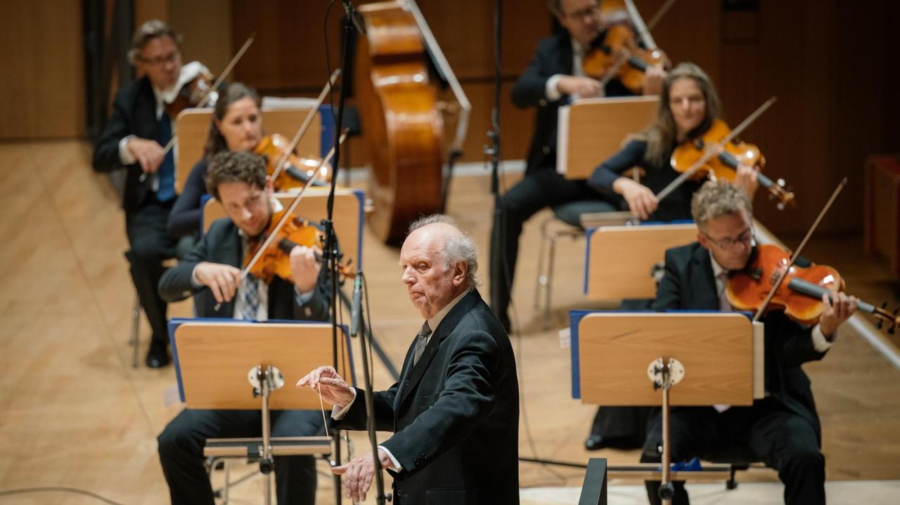 Ein Dirigent steht auf der Bühne und leitet konzentriert eine Aufführung. Ein Dirigent steht auf der Bühne und leitet konzentriert eine Aufführung.