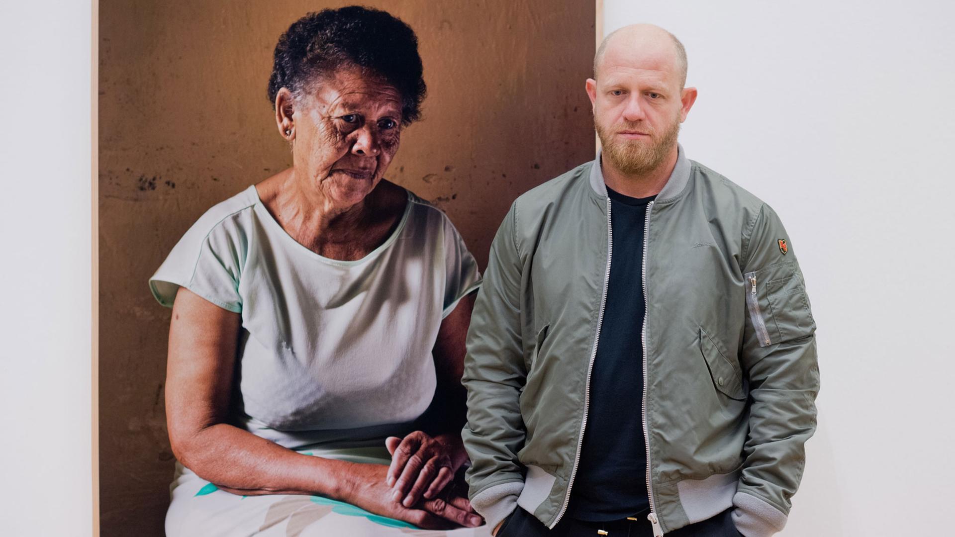 Der südafrikanische Fotokünstler Pieter Hugo steht am 16.02.2017 vor seinem Porträtfoto von Ann Salies (2013) in der Fotografieausstellung «Between the devil and the deep blue sea» im Kunstmuseum Wolfsburg. Es ist die erste institutionelle Einzelausstellung des Fotografen in Deutschland. Hugo beschäftigt sich mit Formen des Zusammenlebens unterschiedlicher Menschen in Diktaturen. Der südafrikanische Fotokünstler Pieter Hugo steht am 16.02.2017 vor seinem Porträtfoto von Ann Salies (2013) in der Fotografieausstellung «Between the devil and the deep blue sea» im Kunstmuseum Wolfsburg. Es ist die erste institutionelle Einzelausstellung des Fotografen in Deutschland. Hugo beschäftigt sich mit Formen des Zusammenlebens unterschiedlicher Menschen in Diktaturen.