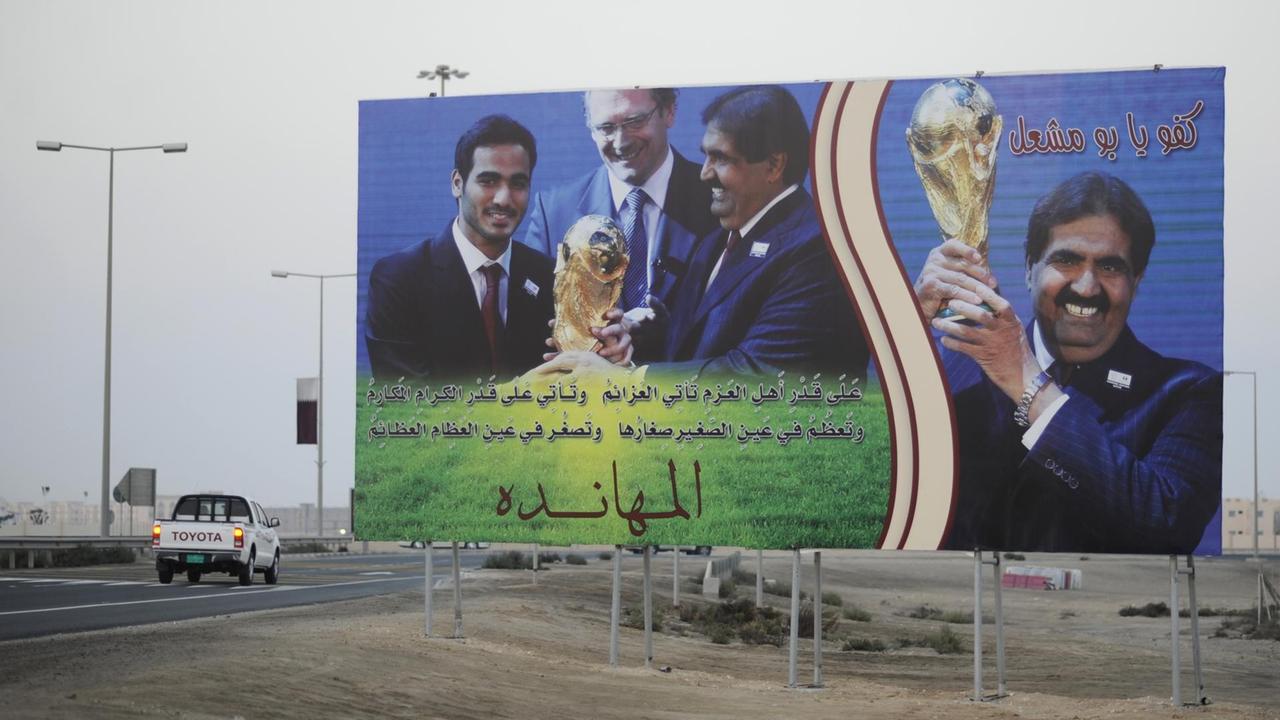 Plakat zeigt Hamad ibn Dschasim ibn Dschabir Al Thani, ehemaliger Premierminister von Katar, der den Fußball-WM-Pokal in Händen hält Plakat zeigt Hamad ibn Dschasim ibn Dschabir Al Thani, ehemaliger Premierminister von Katar, der den Fußball-WM-Pokal in Händen hält