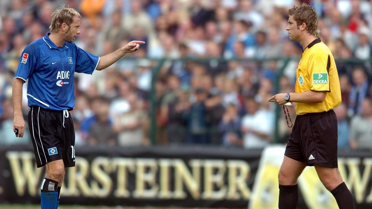 Hamburgs bosnischer Stürmer Sergej Barbarez (l) diskutiert nach dem zweiten Gegentreffer mit Schiedsrichter Robert Hoyzer. Fußball-Bundesligist Hamburger SV verliert am 21.08.2004 im Hermann-Löns-Stadion in Paderborn das DFB-Fußballpokalspiel der 1. Runde gegen den ostwestfälischen Regionalligisten SC Paderborn mit 2:4 und scheidet überraschend aus. | Verwendung weltweit Hamburgs bosnischer Stürmer Sergej Barbarez (l) diskutiert nach dem zweiten Gegentreffer mit Schiedsrichter Robert Hoyzer. Fußball-Bundesligist Hamburger SV verliert am 21.08.2004 im Hermann-Löns-Stadion in Paderborn das DFB-Fußballpokalspiel der 1. Runde gegen den ostwestfälischen Regionalligisten SC Paderborn mit 2:4 und scheidet überraschend aus. | Verwendung weltweit