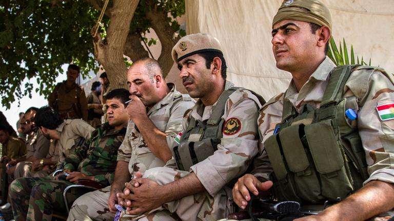 Zu sehen sind kurdische Kämpfer in Uniform mit Waffen. Zu sehen sind kurdische Kämpfer in Uniform mit Waffen.