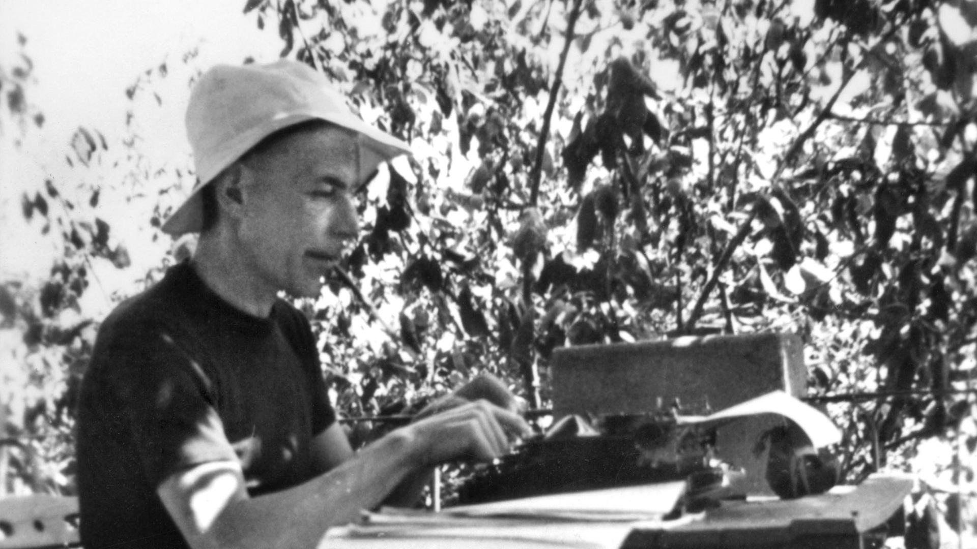 Der Schweizer Schriftsteller Friedrich Glauser im Sommer 1938 in Nervi, wie er an einem Tisch mit Schreibmaschine sitzt.