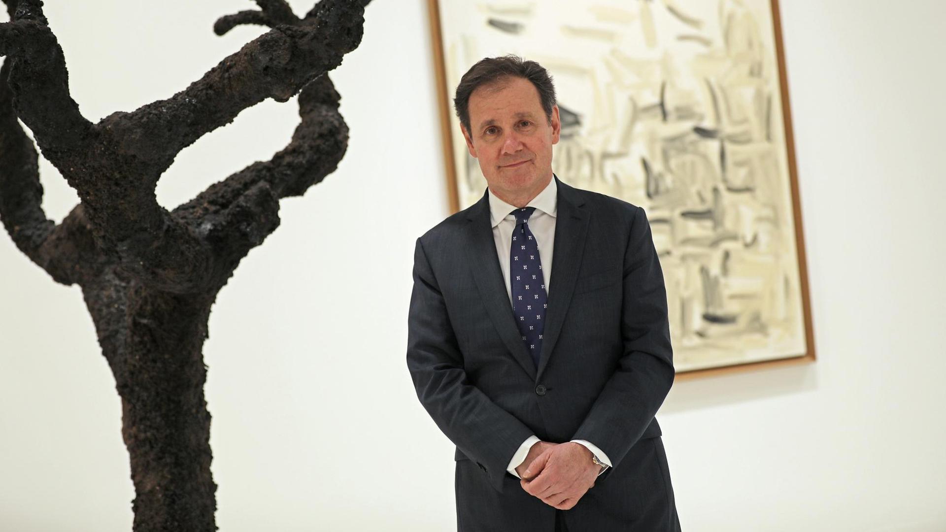 Der Direktor der Maastrichter Kunstmesse, Nanne Dekking, steht vor einem Bild und einem baumartigen Kunstwerk. Der Direktor der Maastrichter Kunstmesse, Nanne Dekking, steht vor einem Bild und einem baumartigen Kunstwerk.