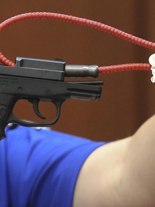 Eine Mitarbeiterin des Sanford Police Departements in Florida zeigt während des Prozesses die Waffe, mit der George Zimmerman den unbewaffneten schwarzen Teenager Trayvon Martin im Februar 2012 erschossen hat.