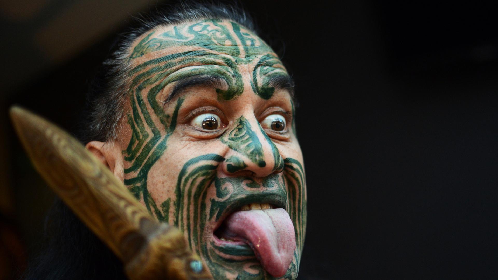 Ein Maori mit einer typischen Gesichtsbemalung und Grimasse. Ein Maori mit einer typischen Gesichtsbemalung und Grimasse.