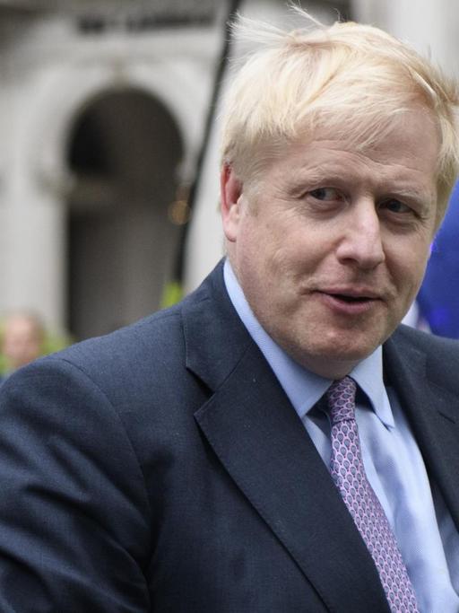 Boris Johnson vor Flaggen der EU.