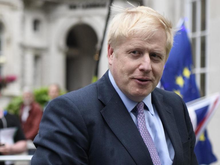 Boris Johnson vor Flaggen der EU.