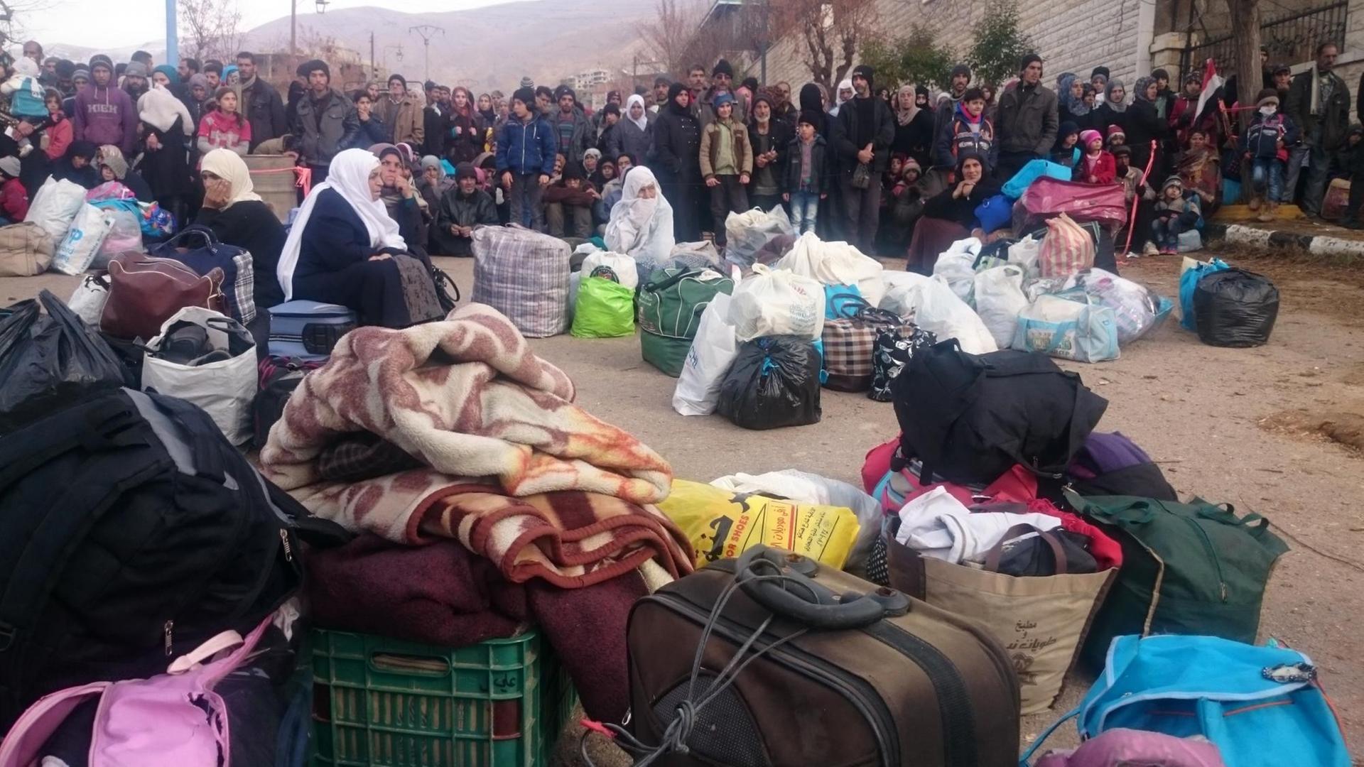 Menschen warten in der belagerten syrischen Stadt Madaja auf die Hilfskonvois mit Nahrungsmitteln und Medikamenten. Menschen warten in der belagerten syrischen Stadt Madaja auf die Hilfskonvois mit Nahrungsmitteln und Medikamenten.