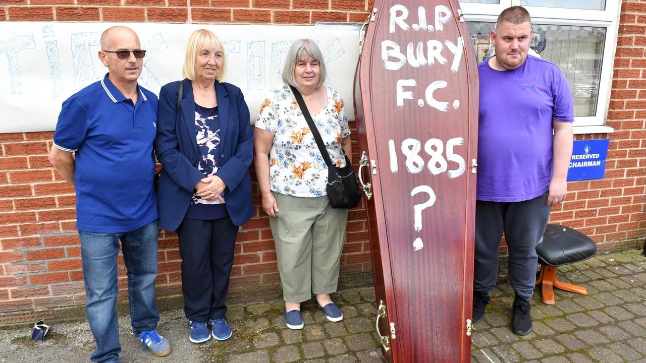 Fans des Fußballklubs Bury FC stehen am 23. August 2019 am Stadion Gigg Lane neben einem Sarg als Symbol für das Ende ihres Vereins. Auf den Sarg haben sie "RIP Bury F.C. 1885?" geschrieben. Fans des Fußballklubs Bury FC stehen am 23. August 2019 am Stadion Gigg Lane neben einem Sarg als Symbol für das Ende ihres Vereins. Auf den Sarg haben sie "RIP Bury F.C. 1885?" geschrieben.