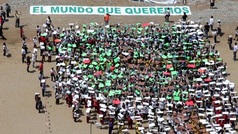 700 Kinder bilden die Form eines Baumes, über dem steht: "Die Welt, die wir wollen" am Strand von Lima, Peru. Hier findet der UN Klimagipfel statt.