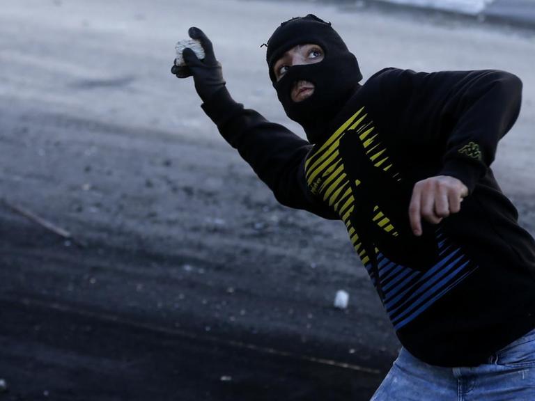 Ein palästinensischer Jugendlicher wirft einen Stein.