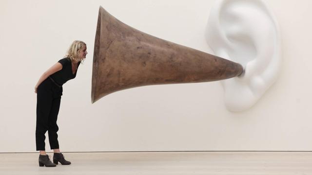 Frau vor der Skulptur Beethoven’s Trumpet (With Ear) von John Baldessari.