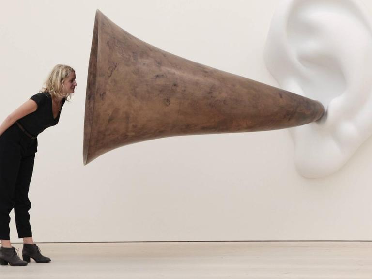 Frau vor der Skulptur Beethoven’s Trumpet (With Ear) von John Baldessari