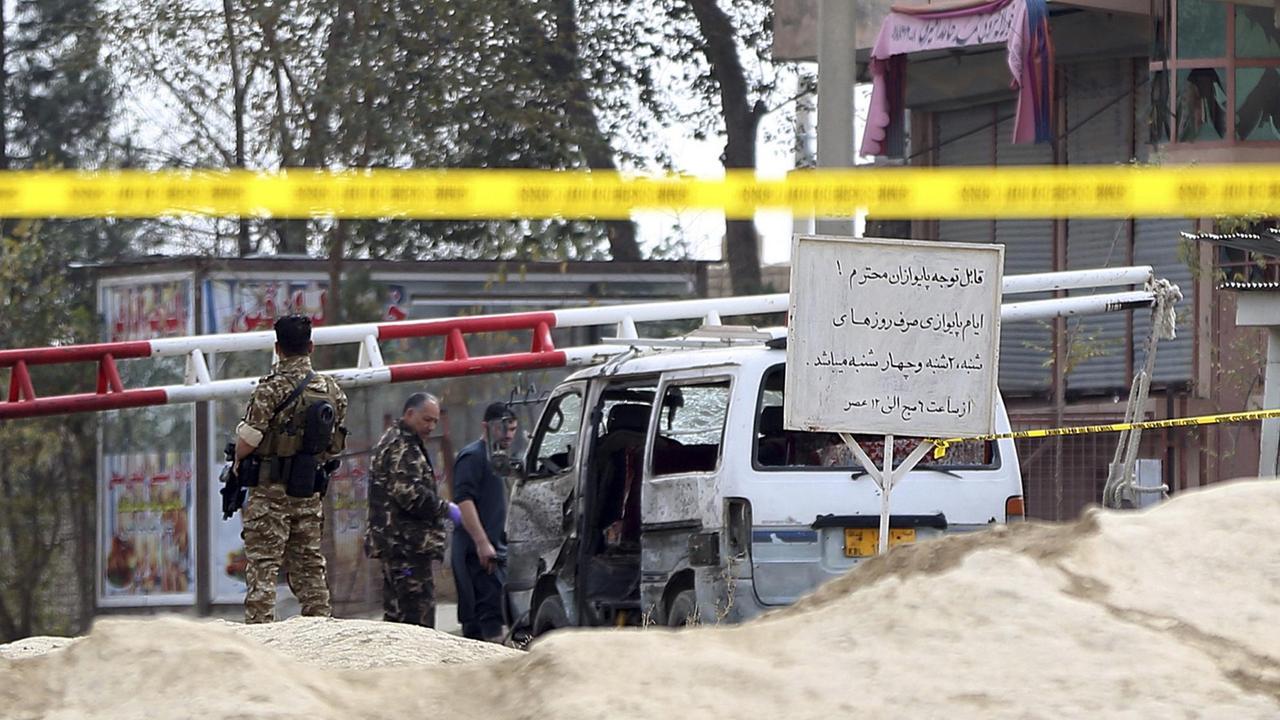 Sicherheitskräfte inspizieren in Kabul ein durch einen Selbstmordanschlag beschädigtes Fahrzeug am Eingang eines Gefängnisses im östlichen Stadtteil Pul-e Charkhi.