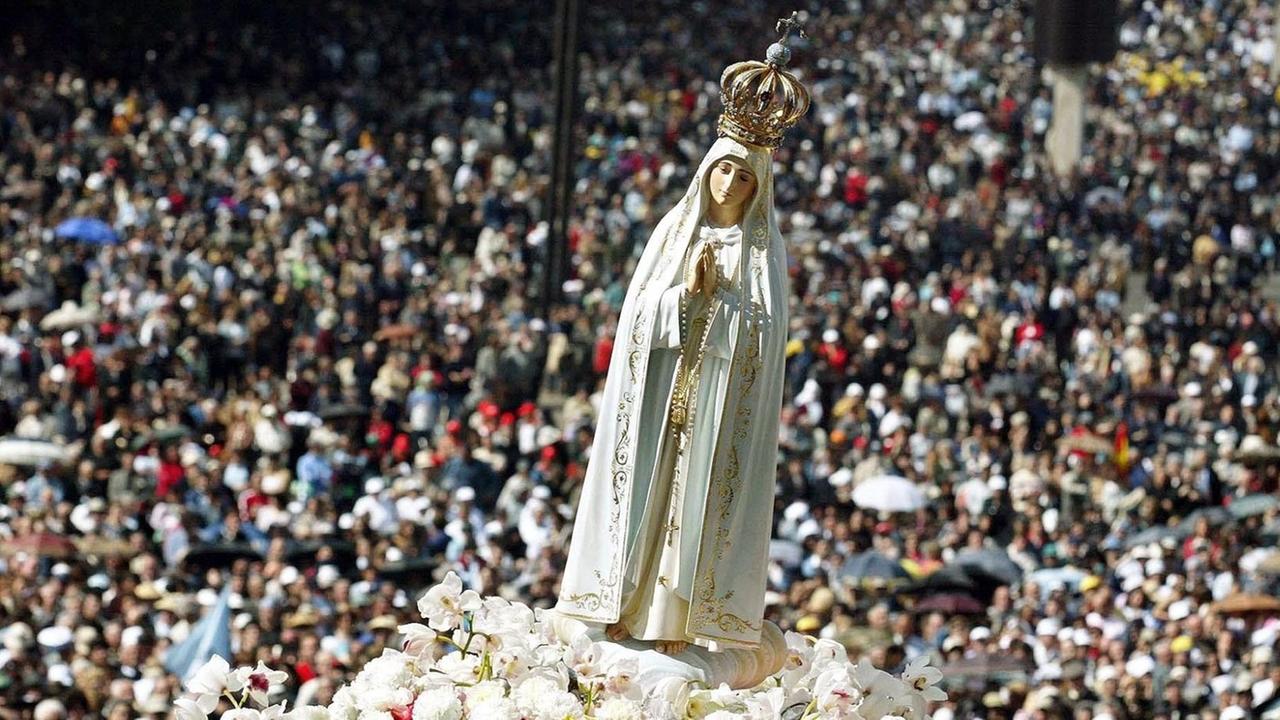Eine Statue der Jungfrau Maria wird während einer Prozession zum Jahrestag einer Muttergottes-Erscheinung getragen. Eine Statue der Jungfrau Maria wird während einer Prozession zum Jahrestag einer Muttergottes-Erscheinung getragen.