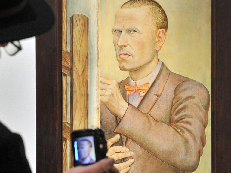 Ein Besucher fotografiert in der Orangerie von Gera in Thüringen ein Selbstbildnis von Otto Dix; Aufnahme vom Dezember 2011 - Zum 120. Geburtstag von Dix war dort eine Retrospektive des Malers und Grafikers zu sehen.